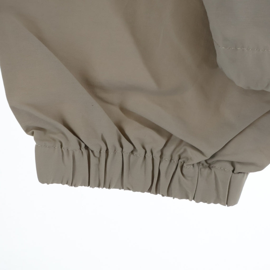 FEAR OF GOD ESSENTIALS(フィアオブゴッド エッセンシャルズ) HALF ZIP NYLON JACKET リフレクターロゴ ハーフジップ ナイロントラックジャケット ベージュ