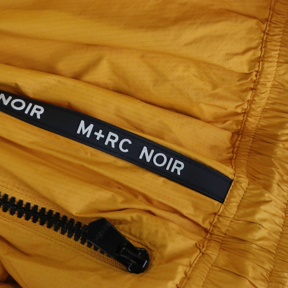 M+RC NOIR(マルシェノア) サイド ロゴテープ ナイロン トラックパンツ オレンジ
