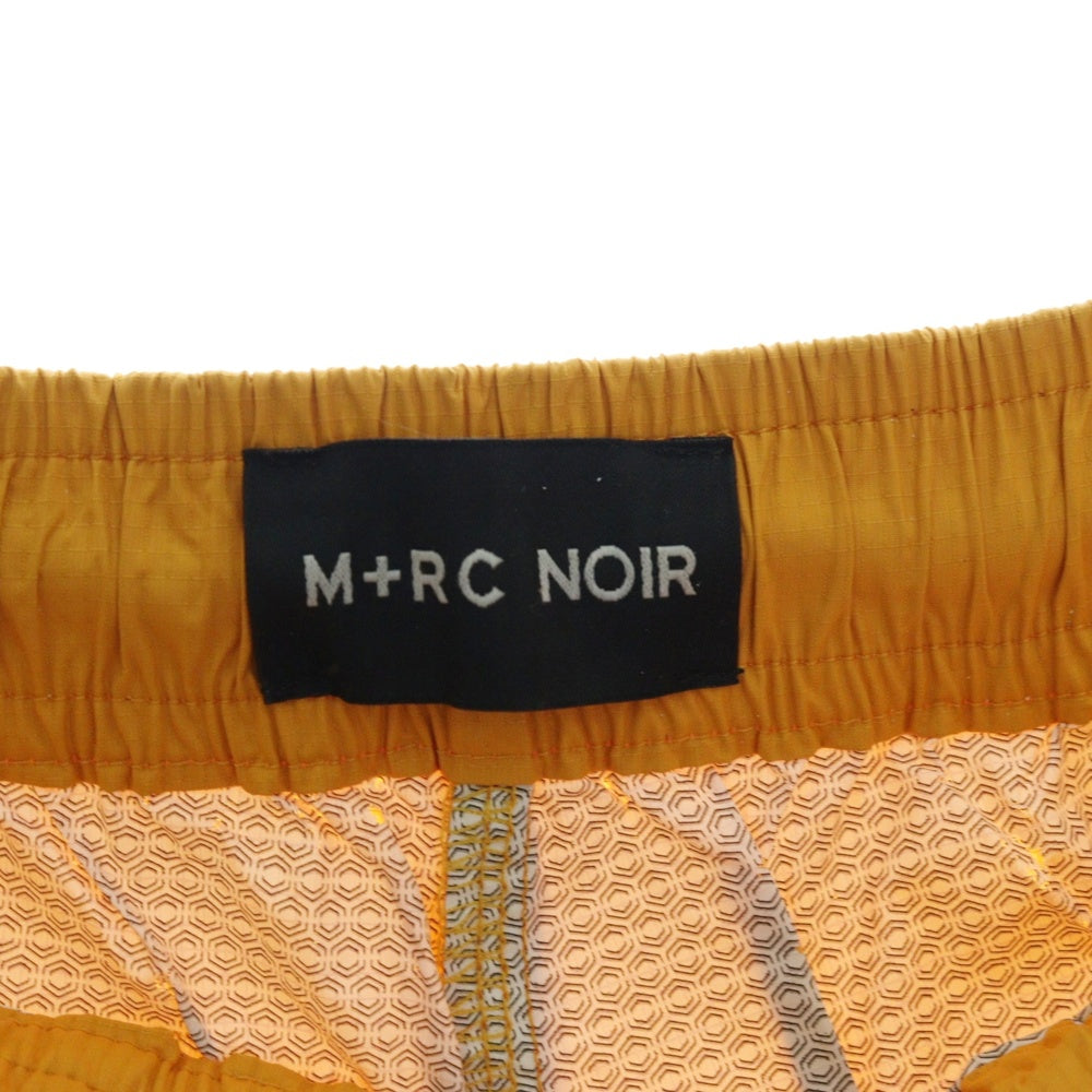 M+RC NOIR(マルシェノア) サイド ロゴテープ ナイロン トラックパンツ オレンジ