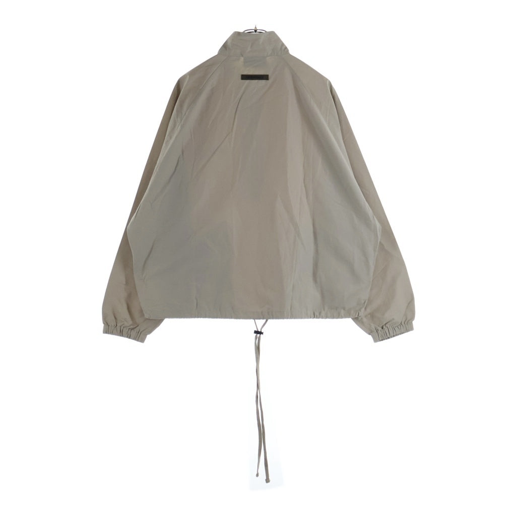 FEAR OF GOD ESSENTIALS(フィアオブゴッド エッセンシャルズ) HALF ZIP NYLON JACKET リフレクターロゴ ハーフジップ ナイロントラックジャケット ベージュ