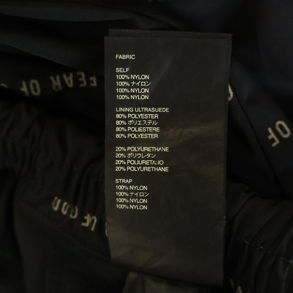 FEAR OF GOD ESSENTIALS(フィアオブゴッド エッセンシャルズ) ロゴ総柄 バックラバーロゴワッペン ナイロン バギーパンツ ブラック