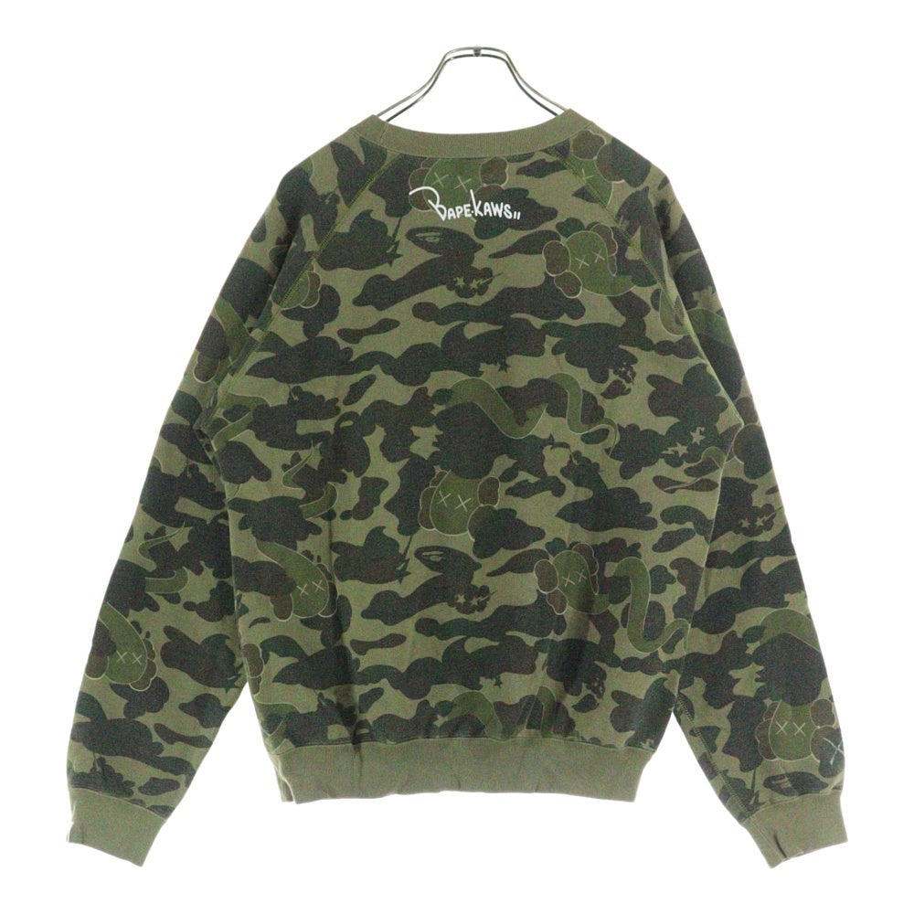 BAPE BY A BATHING APE(ベイプ ア ベイシング エイプ) ×KAWS bendy 1st camo green APE HEAD ×カウズ ベンディー ファーストカモエイプヘッド 総柄クルーネックスウェットトレーナー グリーン