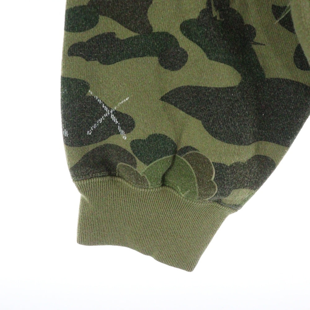 BAPE BY A BATHING APE(ベイプ ア ベイシング エイプ) ×KAWS bendy 1st camo green APE HEAD ×カウズ ベンディー ファーストカモエイプヘッド 総柄クルーネックスウェットトレーナー グリーン