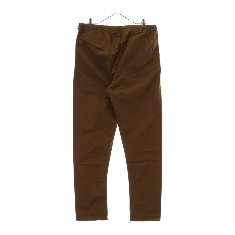 FEAR OF GOD ESSENTIALS(フィアオブゴッド エッセンシャルズ) NYLON PANTS リフレクターロゴ ナイロンパンツ ブラウン