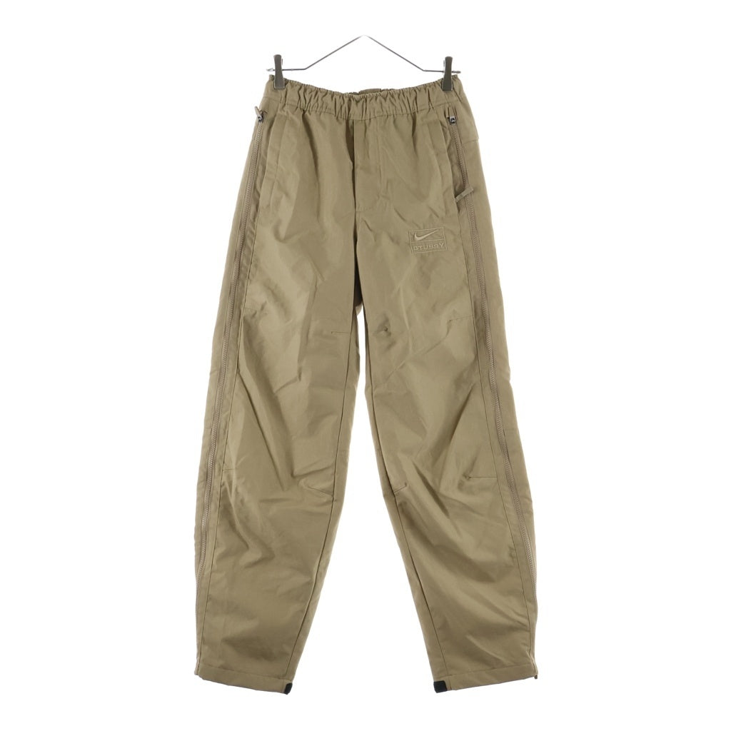 STUSSY(ステューシー) ×NIKE Utility Pant Pine Nut ロゴ 刺繍 ナイロン サイド ライン ジップ パンツ ベージュ